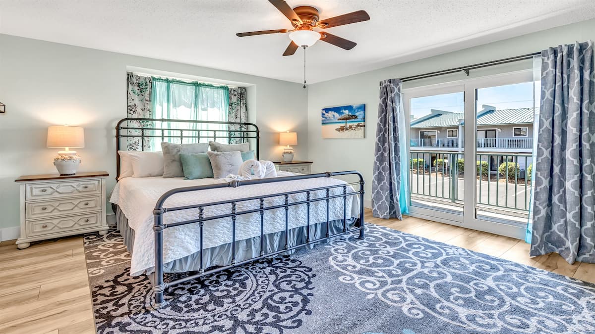 Queen bedroom opening to a balcony overlooking the shared pool